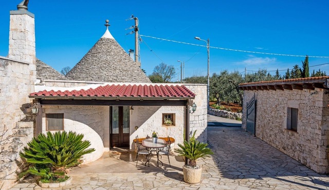 Historic trulli surrounded by ancient olive trees in Coreggia